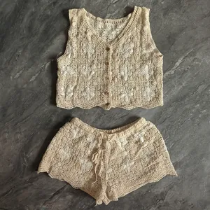 Close-up detail of a bohemian cream crochet knit set with a floral vest and shorts.