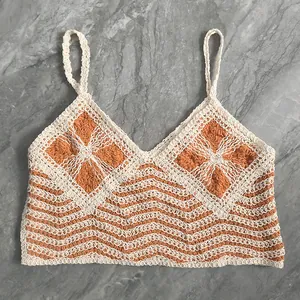 Detail view of a boho-style crochet camisole with intricate orange and cream knit patterns