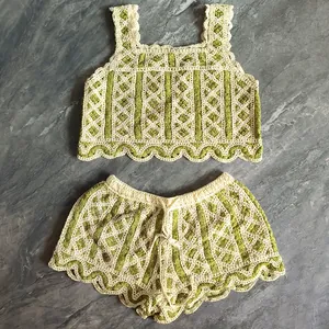 Detailed view of a green and white crochet two-piece knit set with scalloped edge hem