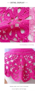 Détail macro montrant la broderie florale rose vif et le motif de dentelle ajourée.