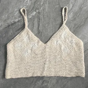 Detailed view of the intricate floral crochet patterns on this beige knit camisole
