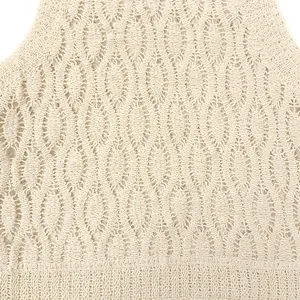 Close-up of the intricate geometric hollow-out texture on the apricot crochet vest
