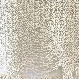 Gros plan de tricot au crochet blanc vintage avec motif ondulé creux et franges