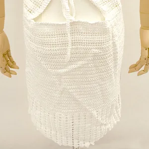 Gros plan détaillé montrant la texture délicate au crochet blanc de cette robe de plage.