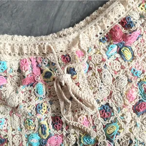 Detailed macro shot of bohemian colorful floral crochet knit fabric with waist drawstring