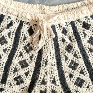 Close-up detail of handmade crochet knit shorts with cream and black striped pattern