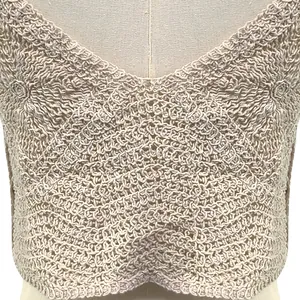 Close-up detail view of a beige crochet lace camisole showing intricate knit pattern