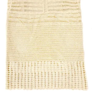 Gros plan sur le motif complexe en crochet de cette robe de plage ajourée de couleur crème