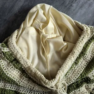 Vue macro détaillée montrant la doublure lisse et la texture en maille crochet verte de l'ensemble