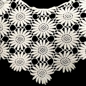 Close-up detail showing the intricate white lace crochet flower pattern of the shawl