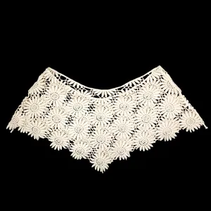 Detail view of intricate crochet lace floral patterns on a beige shawl collar
