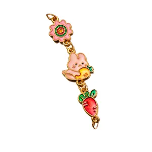 Close-up of colorful enamel rabbit and carrot charm for DIY jewelry making.