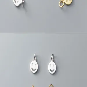 Detailed view of tiny minimalist silver and gold-plated smiley face pendants for DIY jewelry crafts