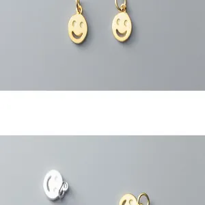 Close-up of gold and silver S925 sterling silver smiley face charms for DIY jewelry making