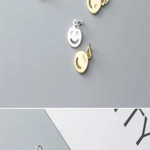 Close-up of S925 silver smiley face pendants with gold and silver plating detail