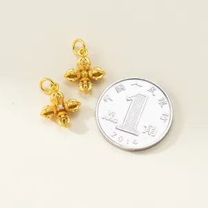 Detailed macro view of gold-plated silver Vajra pendant with scale comparison coin