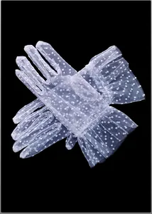 Close-up detail of elegant white sheer mesh polka dot gloves with ruffled cuffs
