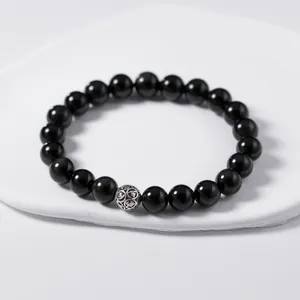 Close-up of black obsidian beaded bracelet with vintage S925 Thai silver filigree bead.