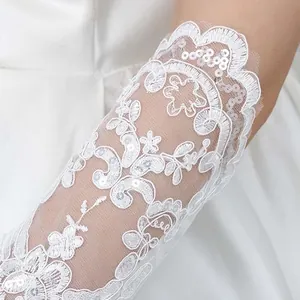 Vista detallada del guante de novia de encaje blanco con bordados y lentejuelas.
