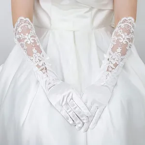 Primer plano de elegantes guantes de novia largos de satén blanco con bordado floral de encaje