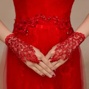 Close-up view of elegant red lace wedding gloves featuring sparkling sequin embroidery details