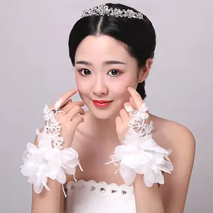 Gros plan détaillé de gants de mariée en dentelle blanche avec fleurs 3D et perles délicates