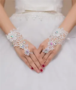 Detailweergave van witte kanten vingerloze bruidshandschoenen met gekleurde strass-accenten