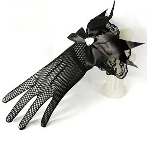 Close-up of black fishnet bridal glove with large satin bow and heart rhinestone detail.