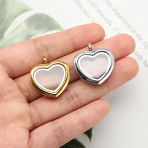 Close-up detail of heart-shaped gold and silver stainless steel lockets on a palm.