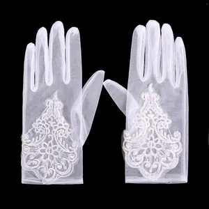 Detailed view of elegant white lace embroidery on sheer mesh bridal wedding gloves