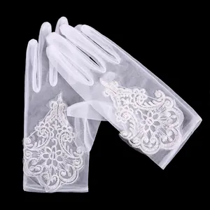 Close-up detail of white sheer mesh bridal gloves showing intricate lace embroidery