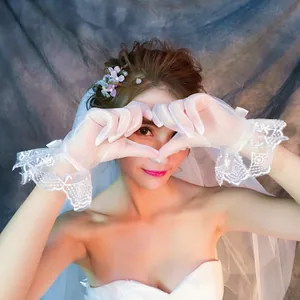 Eleganti guanti da sposa in pizzo bianco con bordi a balze per servizi fotografici