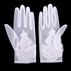Detailed view of sheer white wedding gloves featuring elegant lace embroidery pattern