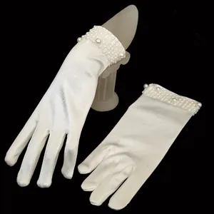 Detailed macro view of white satin bridal gloves featuring elegant beaded pearl cuffs