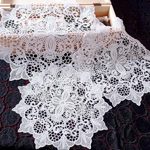 Close-up of white embroidered lace doilies with intricate hollow-out floral patterns