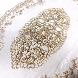 Macro detail of gold embroidery floral patch on fine white mesh background