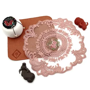 Detailansicht eines rosa wasserlöslichen Tischsets aus Spitze mit Rosenstickerei