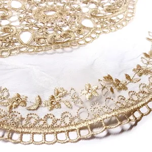 Macro detail of elegant golden floral embroidery on white mesh lace fabric