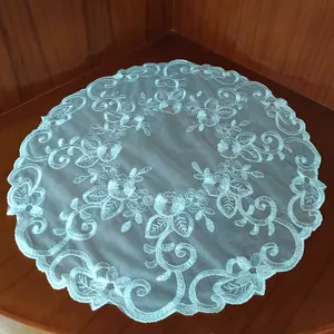 Macro detail shot of a white lace circular doily with intricate floral embroidery