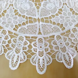 Detailansicht der weißen bestickten Spitzentischdecke mit filigranem hohlem Blumenmuster