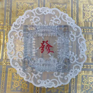Close-up of white embroidered lace mat featuring intricate floral and hollowed-out designs