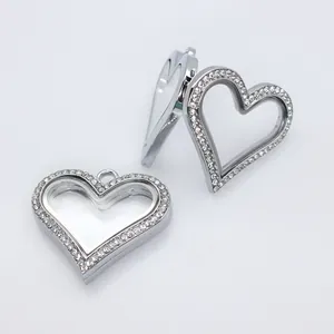 Close-up of heart-shaped silver alloy locket pendant with rhinestones and glass panel details
