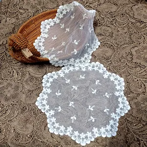 Close-up of vintage round embroidered lace coaster on elegant background tablecloth