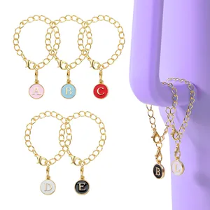 Close-up of gold chain keychain featuring colorful initial letter charms on a handle