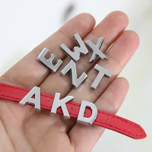 Close-up detail of 10mm silver alloy alphabet slide charms displayed on a red leather strap