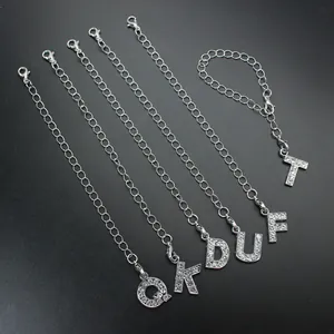 Close-up view of silver keychain chains featuring lobster clasps and rhinestone letters