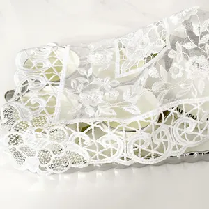 Close-up detail of elegant white embroidered lace dust cover with floral mesh patterns