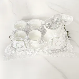Elegant white lace embroidered dustproof cover cloth overlaying ceramic tea cups