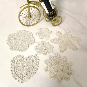 Detailed view of various vintage white lace coasters in heart and floral embroidery shapes.