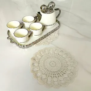 Detailansicht des filigranen Häkelmusters auf dem runden Vintage-Spitzentischset